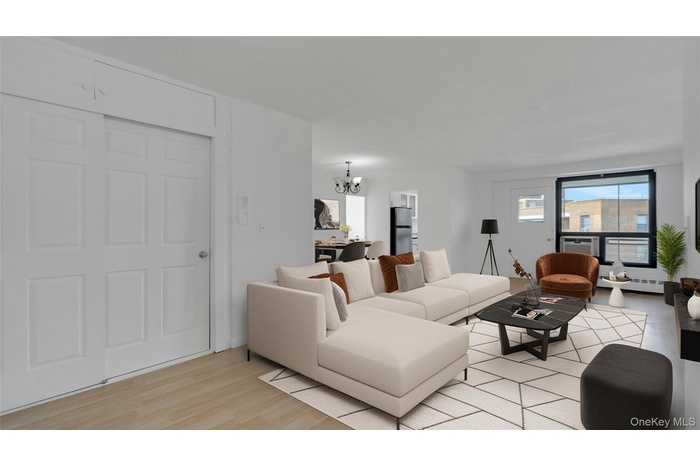Living area with a chandelier, light wood finished floors, and a baseboard heating unit