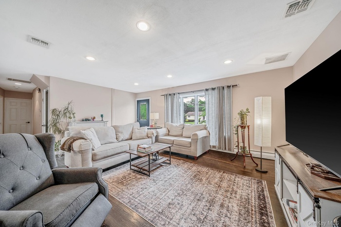 Living area with dark wood-style floors and recessed lighting