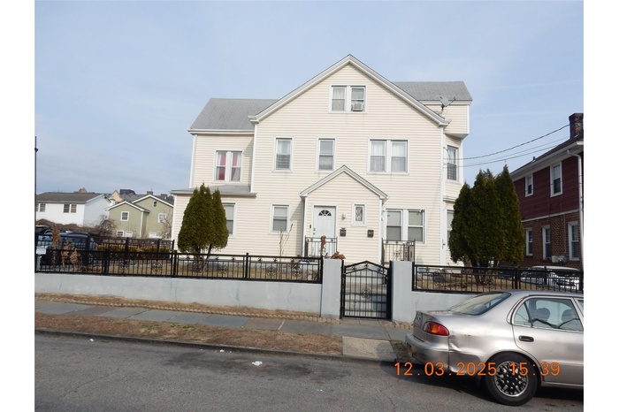 Townhome / multi-family property featuring a fenced front yard and a gate