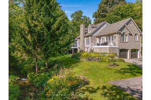 Welcome to 1298 West River Road Tranquility Meets Timeless StyleSurrounded by mature trees and a gentle stream, this bungalow loft blends peaceful country living with city convenience just minutes away.