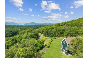 Wooded retreat meets modern comfort in this breathtaking Garrison home, perched atop a gently rolling hill on 5.