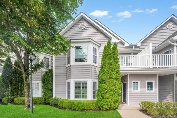 Traditional home with a balcony and a front lawn