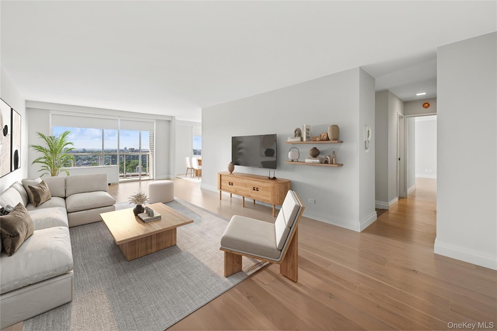 Virtually staged living room with light wood-style floors and floor to ceiling windows