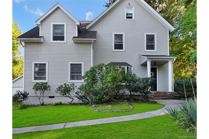 View of front of property with a front lawn and roof with shingles