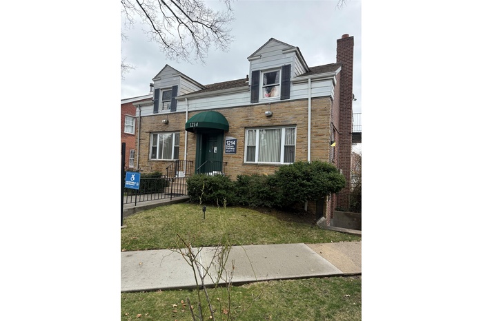 View of front of house featuring a chimney and a front yard