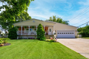 This expanded cape home offers four bedrooms, three full baths, and two half baths on a flat quarter acre lot with mature fig trees.