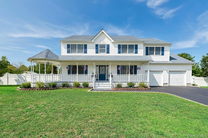 View of front of house with covered porch, asphalt driveway, a garage, and a shingled roof