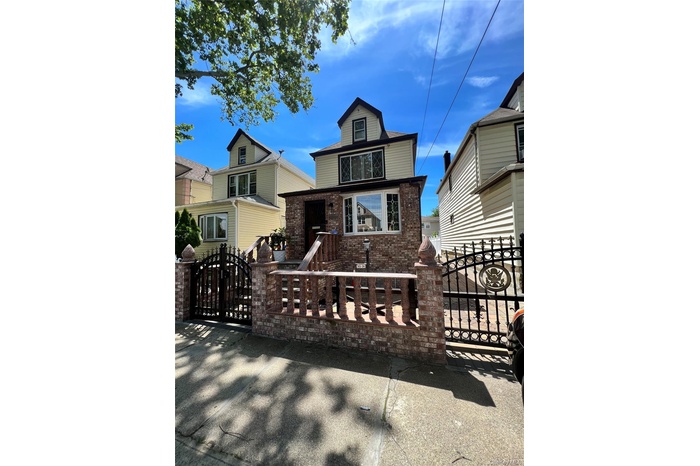 View of front of house featuring a gate, brick siding, and a fenced front yard