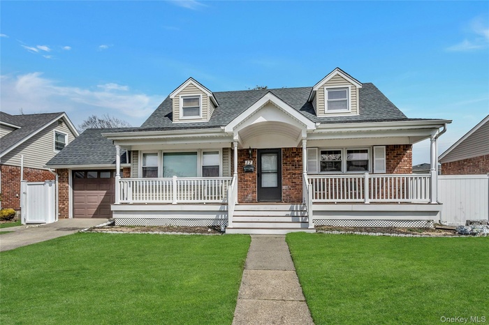 Cape cod-style house with brick siding, a porch, and a shingled roof