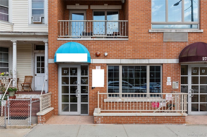 Doorway to property featuring brick siding and a gate