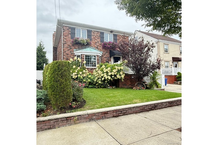 View of front of property with a front yard and brick siding