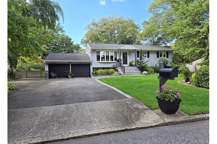 Ranch-style home featuring roof with shingles and driveway