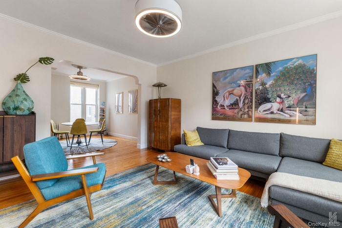 Living room featuring crown molding, wood finished floors, and arched walkways