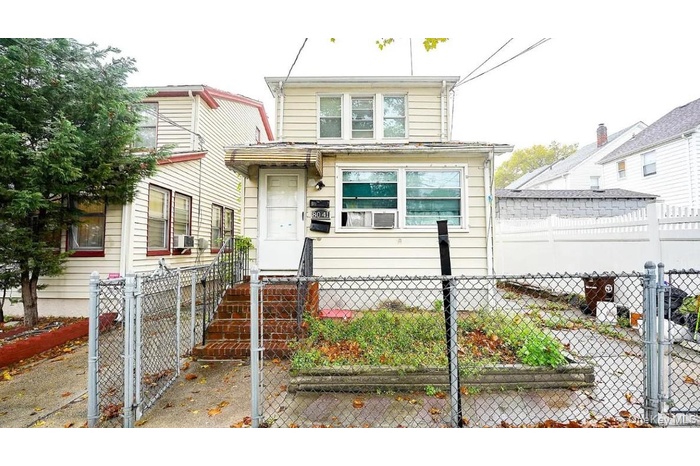 View of front of property with a fenced front yard and a gate