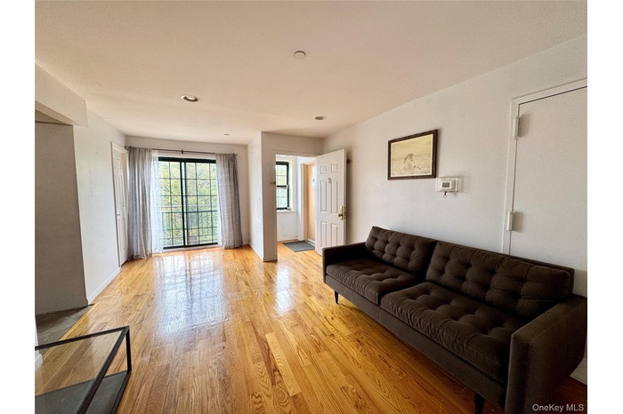 Living room with light wood finished floors and recessed lighting