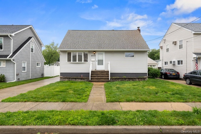 Bungalow-style home featuring a front lawn and a shingled roof