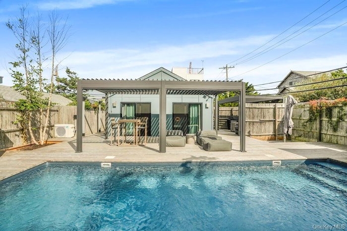 Back of property with a pergola, a fenced backyard, and a deck