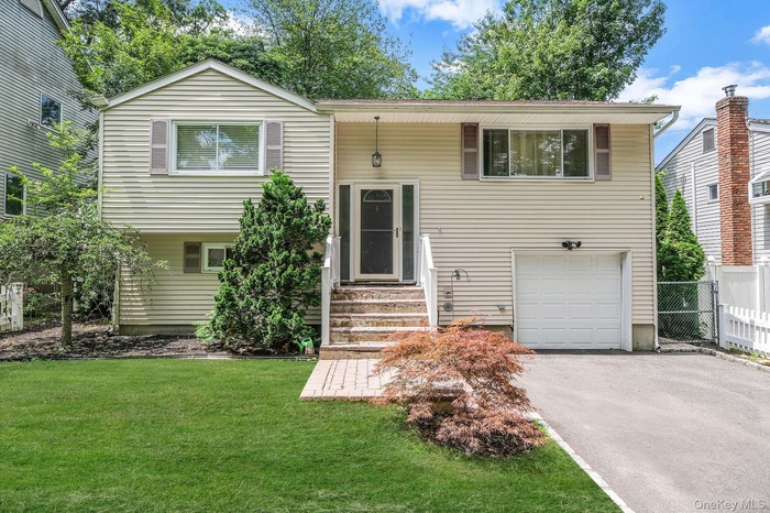 Bi-level home with driveway and an attached garage