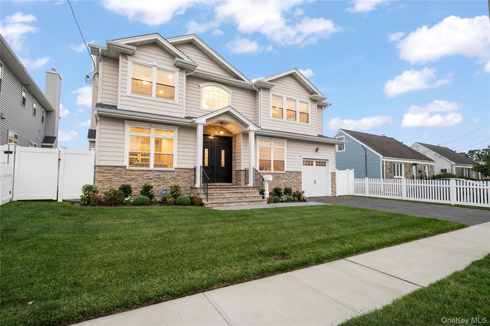 Craftsman house featuring a gate, asphalt driveway, stone siding, and a residential view