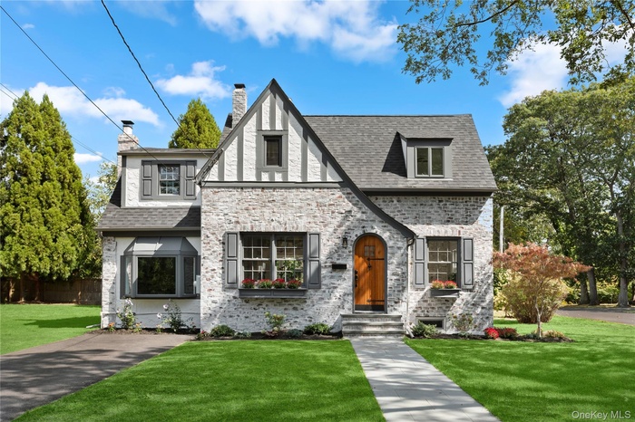 Tudor-style house featuring a front yard and a chimney