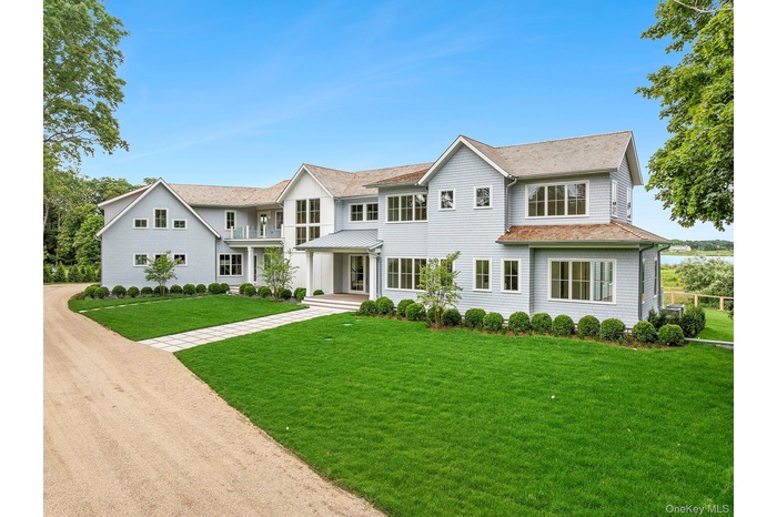View of front facade featuring a front yard and driveway