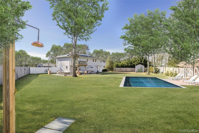 Fenced backyard featuring a patio and a shed