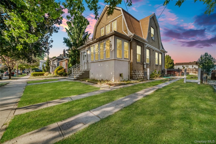 Property exterior at dusk with a gambrel roof