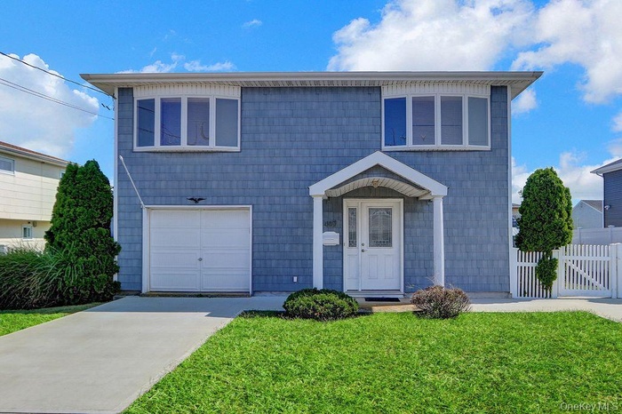 Traditional-style house featuring concrete driveway and an attached garage
