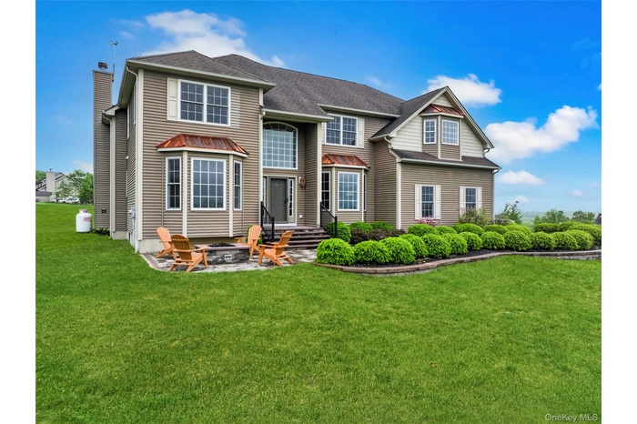 Rear view of property featuring an outdoor fire pit, a yard, a chimney, a shingled roof, and a patio area