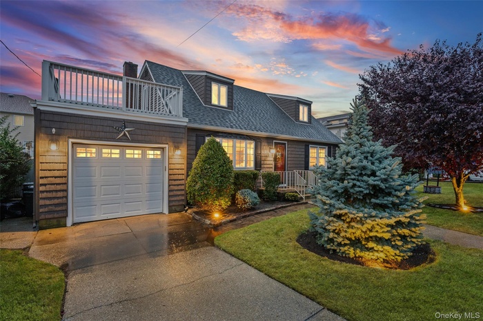 View of front of home featuring roof with shingles, driveway, a chimney, a garage, and a lawn