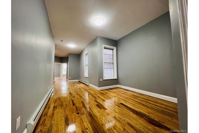 Spare room featuring a baseboard heating unit, light wood-style floors, and a baseboard radiator