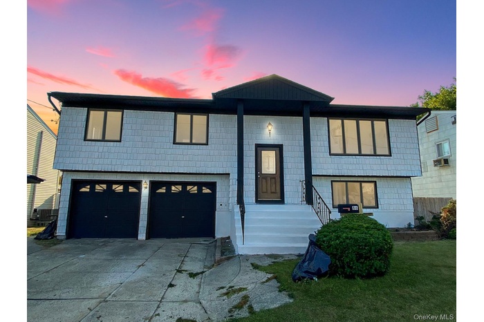 Raised ranch with driveway and an attached garage
