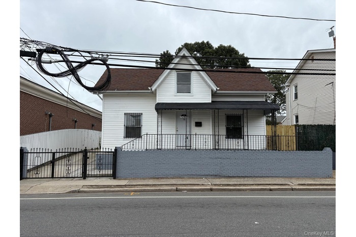 View of front of property with a fenced front yard and covered porch
