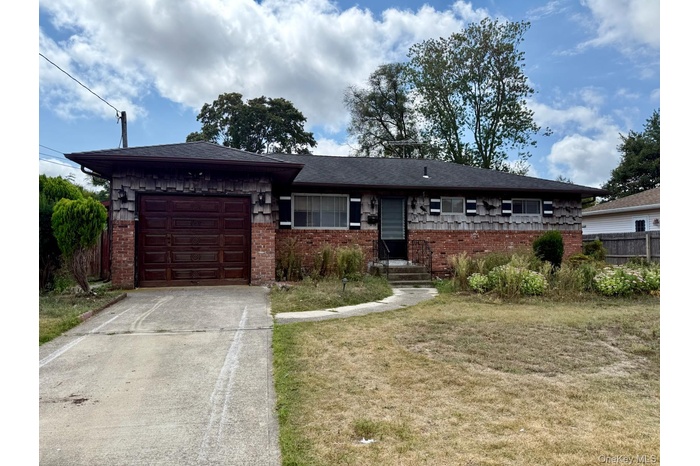Single story home with an attached garage, concrete driveway, and brick siding