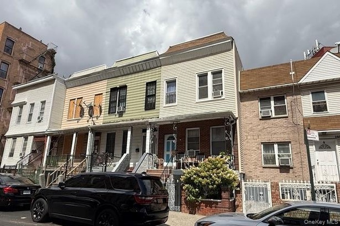 View of front of house with cooling unit and brick siding