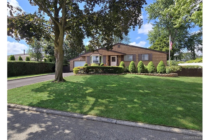 Single story home featuring asphalt driveway and a garage