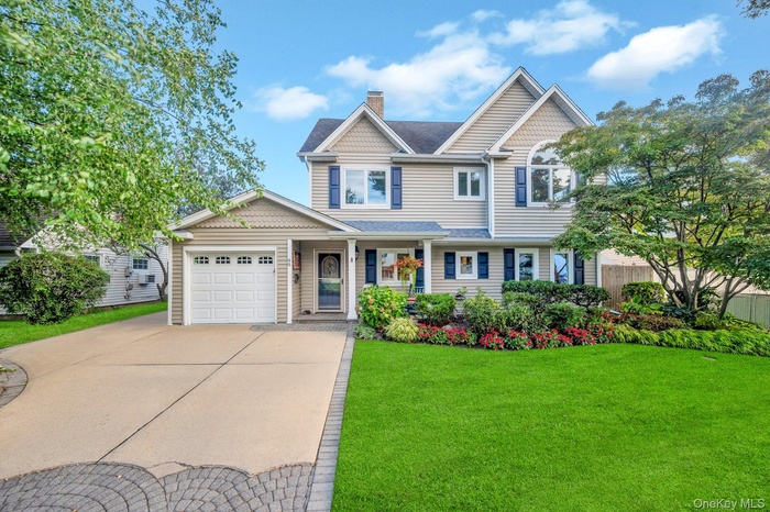 View of front of property featuring driveway, a chimney, a porch, an attached garage, and a shingled roof