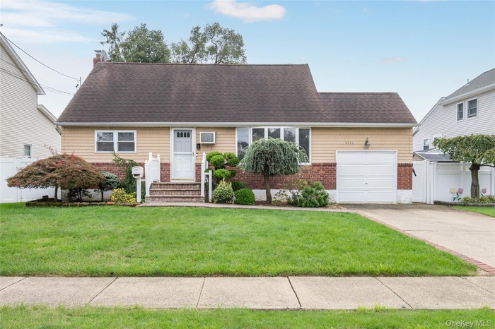 View of front of property featuring concrete driveway, an attached garage, brick siding, a chimney, and a shingled roof