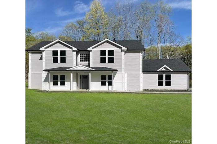 View of front of property featuring a porch and a front yard