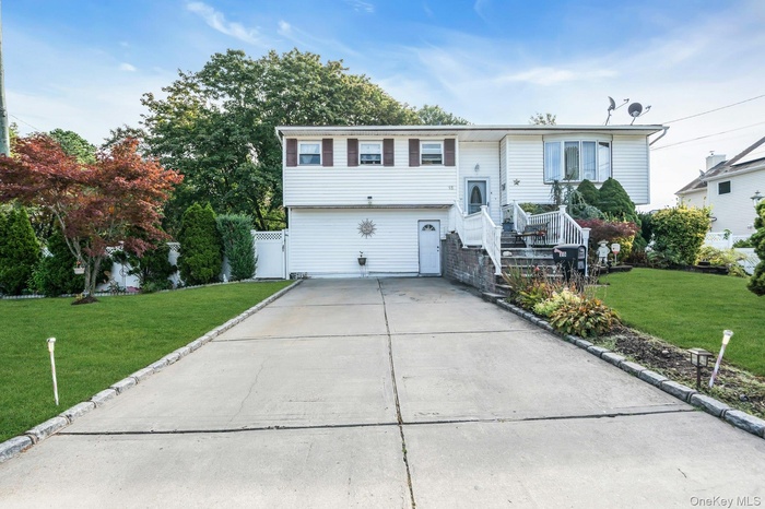 Bi-level home with a front yard and driveway