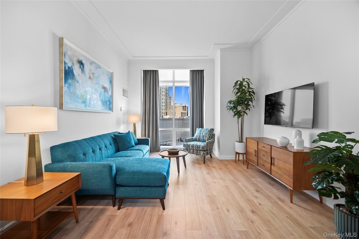 Living area featuring light wood-type flooring and ornamental molding