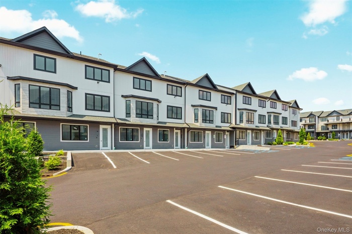 View of property featuring uncovered parking