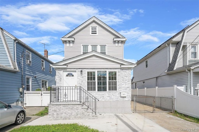 View of front of home with a gate and stone siding