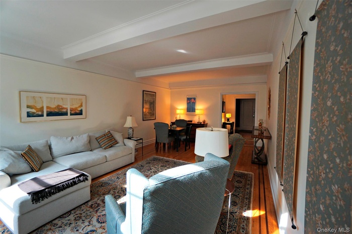 Living area with beamed ceiling and wood finished floors