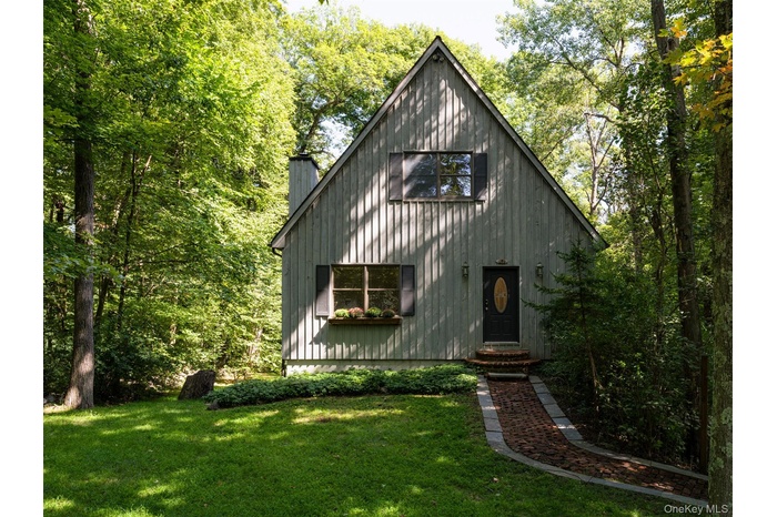 View of front of house with a chimney and a front lawn