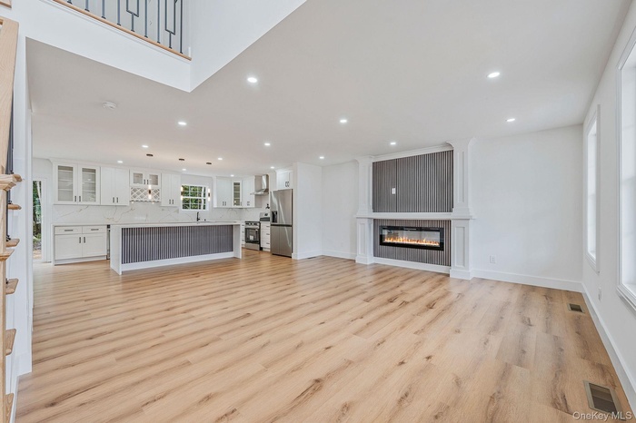 Unfurnished living room with a fireplace, light wood-type flooring, and recessed lighting