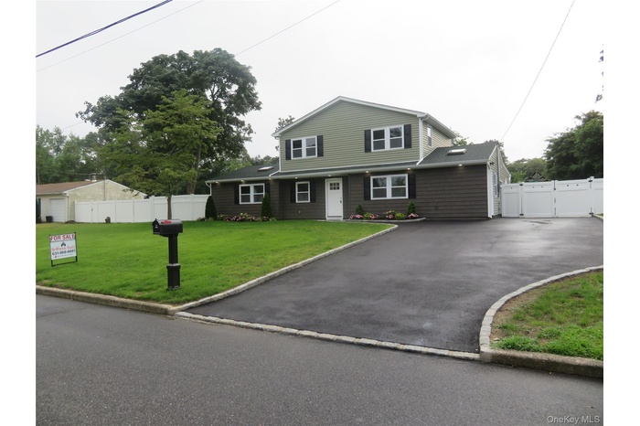 Traditional home featuring a gate and driveway