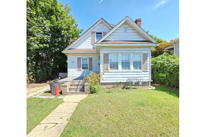 Bungalow-style house with a front yard, a chimney, and a shingled roof
