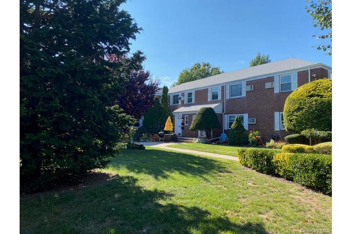 View of front of house with a front lawn and brick siding