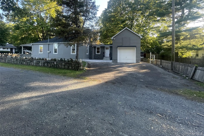 View of front of home featuring driveway, a garage, and covered porch